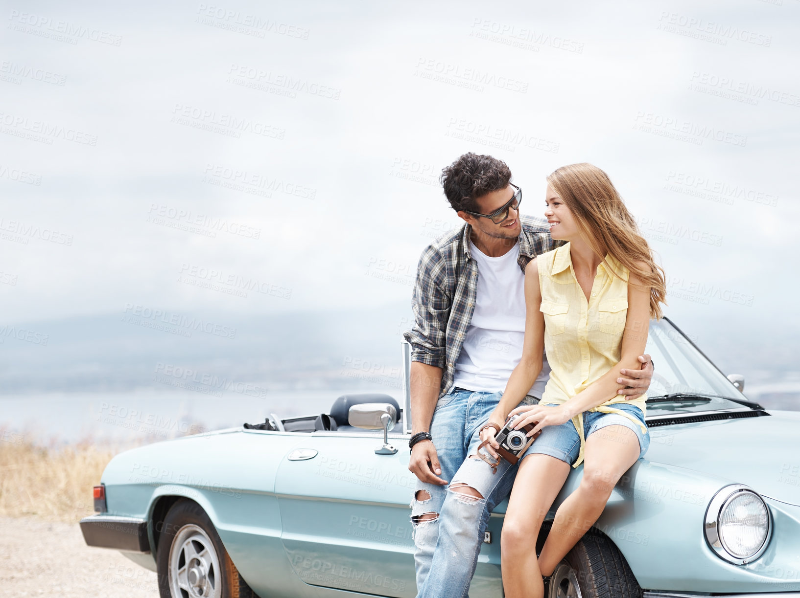 Buy stock photo Travel, road trip and couple by car with camera for love, holiday journey and happy memory for honeymoon. Outdoor, man and woman by convertible motor with tech for photography and vacation adventure