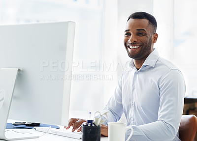 Buy stock photo A handsome young african american businessman working at his desk