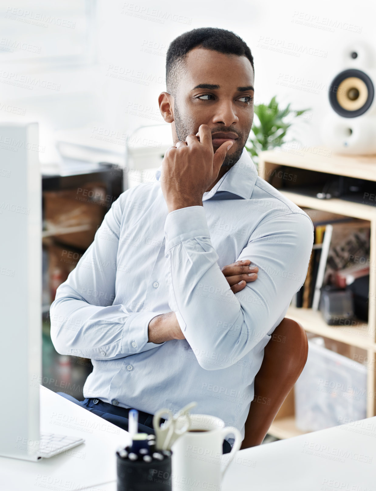 Buy stock photo A handsome young african american businessman sitting at his desk