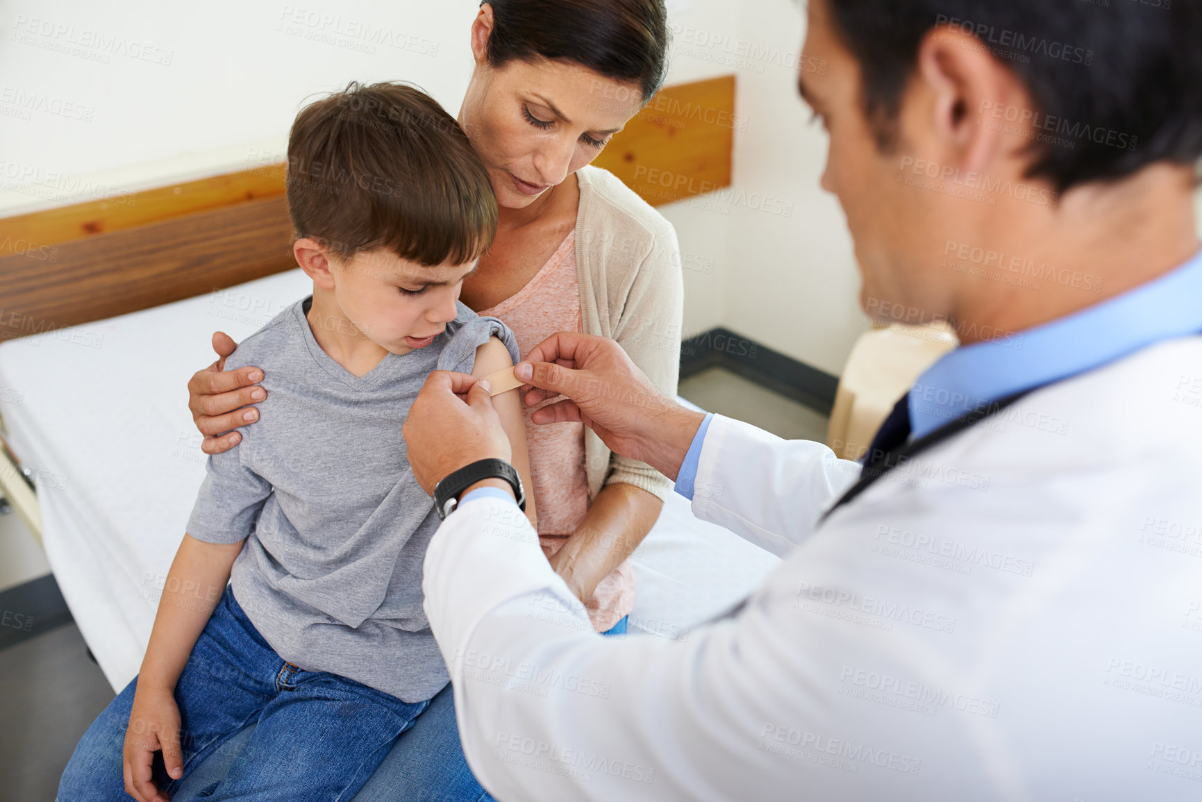 Buy stock photo  Aerial shot of a doctor placing a plaster on his patient's arm