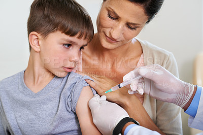 Buy stock photo Shot of a boy watching his doctor inject him