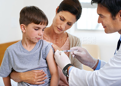 Buy stock photo Shot of a brave young boy receiving an injection in his arm