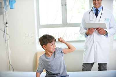 Buy stock photo Shot of a young boy displaying his strength and bravery by flexing his arm 