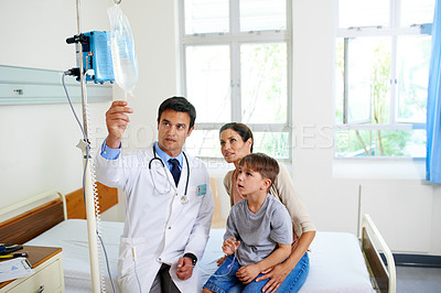 Buy stock photo Shot of a mother son and doctor looking at a drip with interest