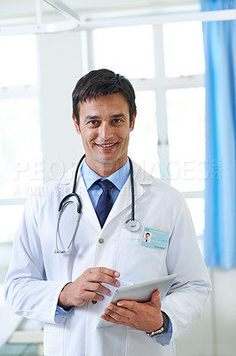 Buy stock photo Portrait of a handsome young doctor using a tablet