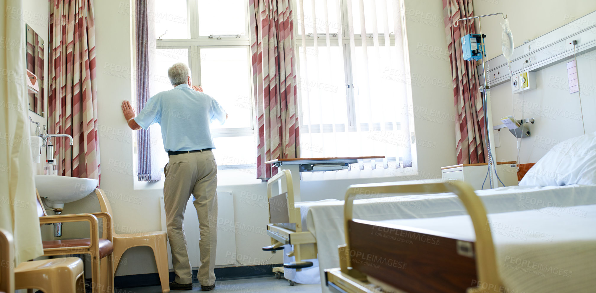 Buy stock photo Shot of a senior man looking out a window while he waits in a hospital ward