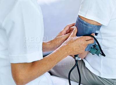 Buy stock photo Closeup shot of a doctor testing a patient's blood pressure