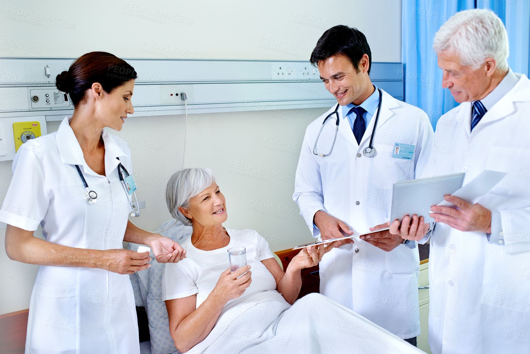 Buy stock photo Shot of three doctors attending a senior patient who is in a hospital bed