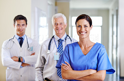 Buy stock photo Portrait of three smiling doctors standing in a corridor