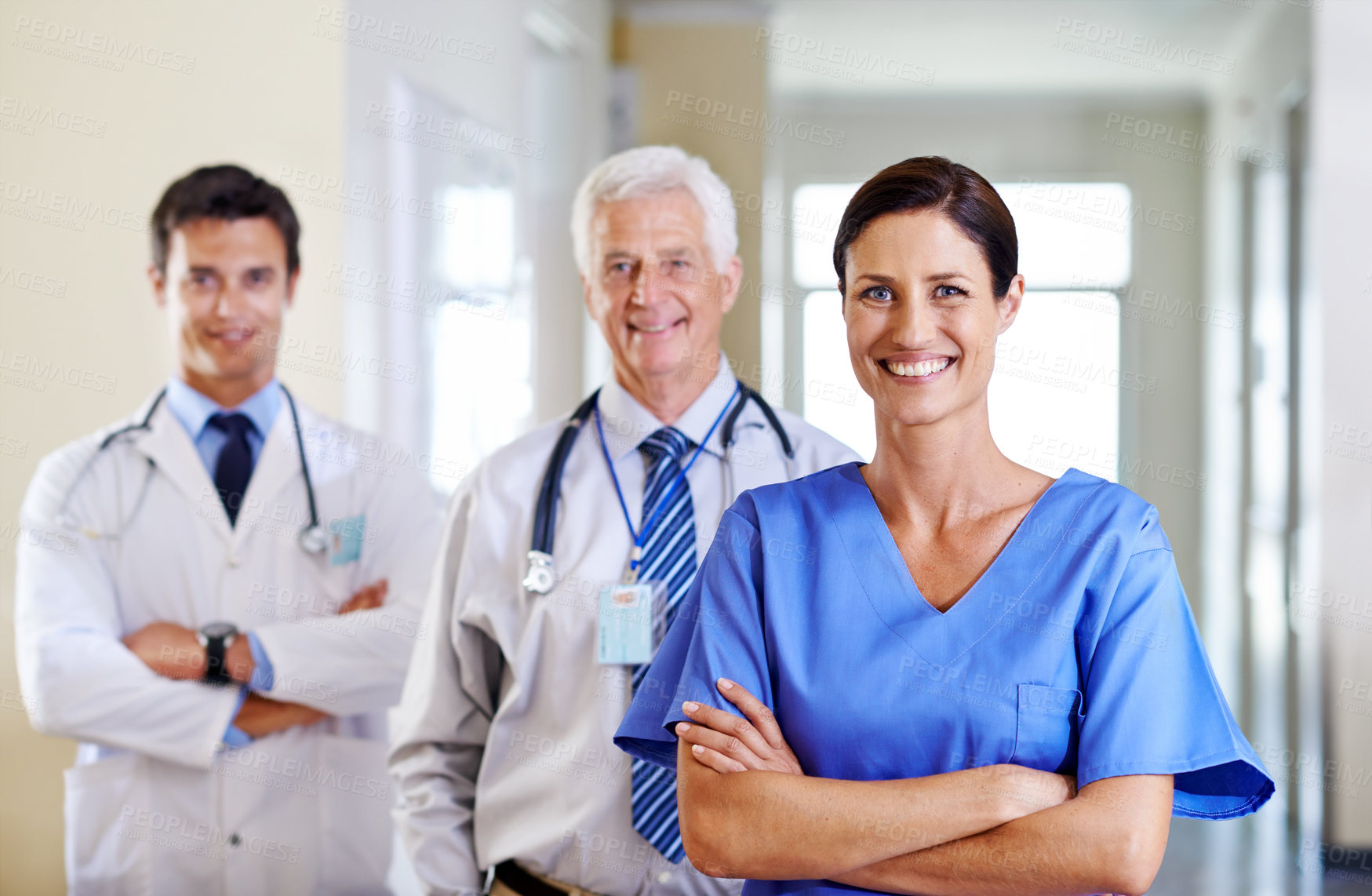 Buy stock photo Portrait of three smiling doctors standing in a corridor