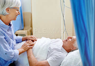 Buy stock photo Shot of a senior woman comforting her sick husband who is lying in a hospital bed