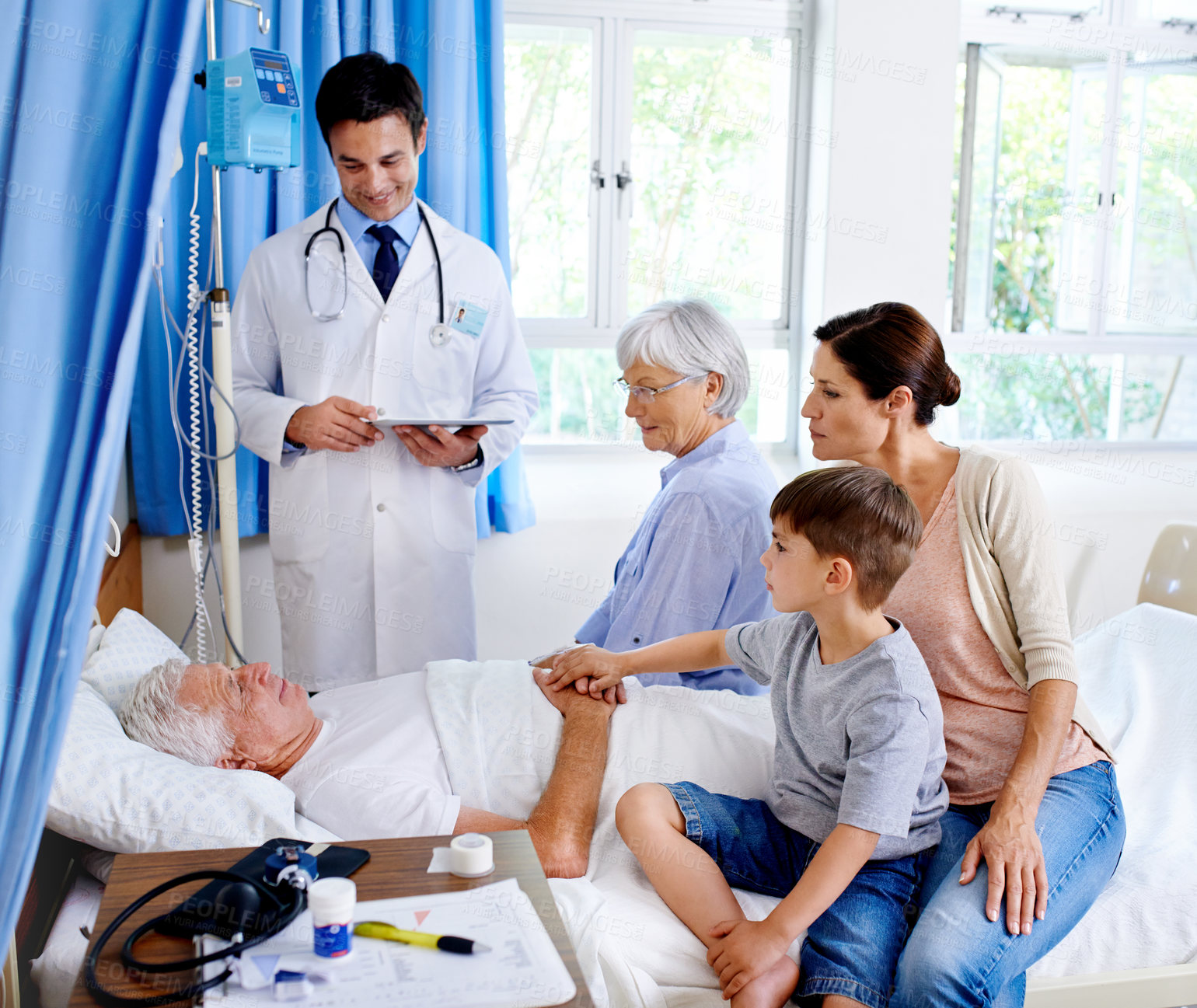 Buy stock photo Man, doctor and family on bed in hospital, medical professional and diagnosis with tablet for senior patient. People, support and love for visiting or healthcare, hospitalized and illness treatment