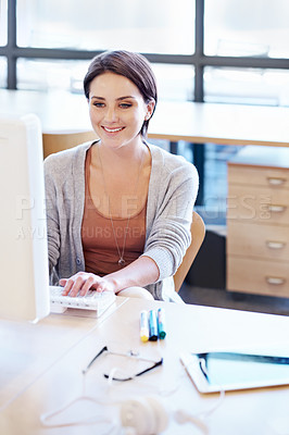 Buy stock photo Shot of an attractive young woman working at a computer in an office