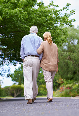 Buy stock photo Back view, road or senior couple walking to relax and enjoy bonding together in retirement for peace. Love, mature woman and elderly man on street with care, support and health in quiet neighborhood