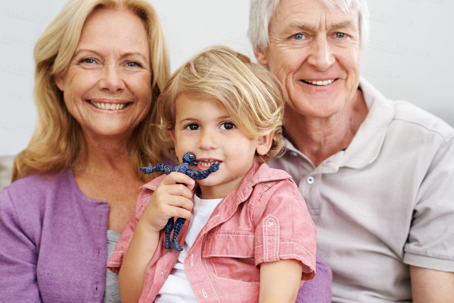 Buy stock photo Shot of a senior couple sitting with their adorable grandson