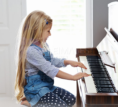 Buy stock photo Girl, lesson and playing piano in home, learning musical instrument and practice performance. Female person, child and classic keys for pianist skill, hobby and melody sound for talent development