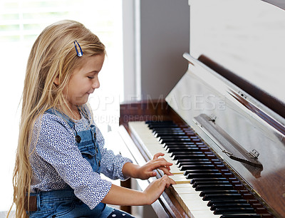 Buy stock photo Piano, child and learning in home for music, development and happy for practice in lounge. Keys, creativity and girl or kid in living room with musical instrument for sound, talent and audio for art