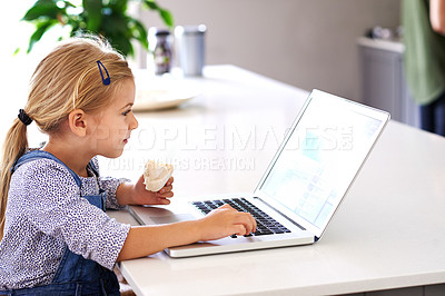 Buy stock photo Shot of a cute little girl using a laptop while having a snack