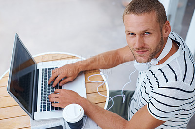Buy stock photo High angle shot of a handsome young man working on a laptop outside