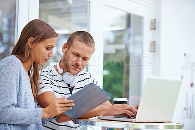 Buy stock photo Shot of a young couple working together at a table outside a cafe