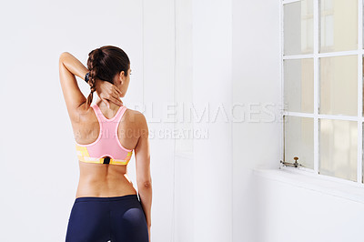 Buy stock photo Rearview shot of an attractive young woman stretching for a workout