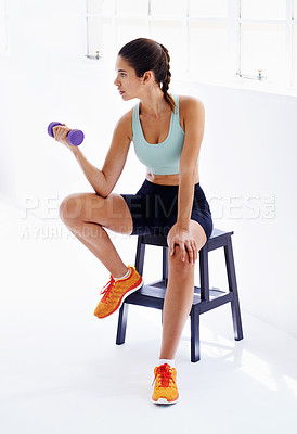 Buy stock photo Woman, fitness and weightlifting with dumbbell on chair for workout, exercise or training at indoor gym. Young female person lifting weight for bicep curl, muscle gain or strength at health club