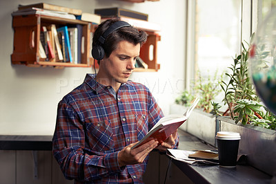 Buy stock photo Man, headphones and reading book to relax at cafe, literature and student to study on campus. Male person, novel and learning english for journalism at coffee shop, espresso and podcast for info