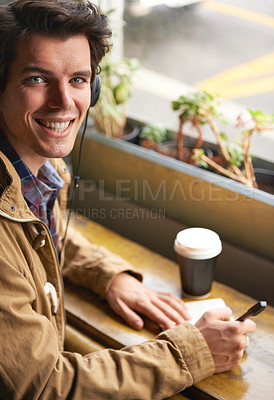 Buy stock photo Student, portrait and coffee in cafe with notebook for study, planning and writing in journal or diary. Man, happy and latte in restaurant with book and headphones for notes, brainstorming and music