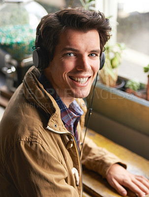 Buy stock photo Man, portrait and smile in cafe with headphones for streaming, radio and listen to track, song or album. Student, happy and face in restaurant with audio and sound for podcast, lunch break and music