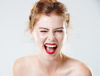 Buy stock photo Studio shot of a beautiful young woman with bare shoulders winking at the camera