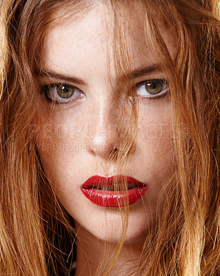 Buy stock photo Studio portrait of an edgy young woman's face wearing red lipstick and looking sexy with attitude. Glamorous female model with beautiful soft skin and radiant ginger hair looking serious and elegant