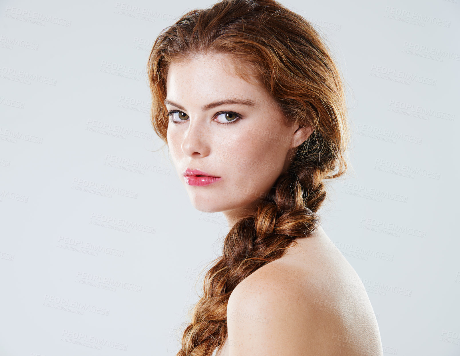 Buy stock photo Studio portrait of a beautiful young woman with braided hair looking over her bare shoulder