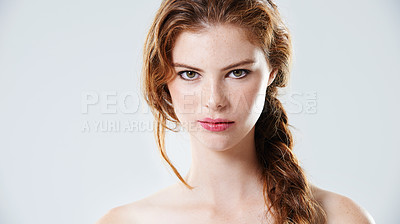 Buy stock photo Studio portrait of a beautiful young woman with braided hair standing against a gray background