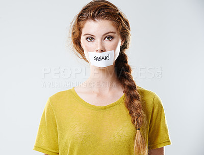 Buy stock photo Portrait of a woman with speak on her mouth isolated with a white background. Female with a sticker label on her lips. Young lady in protest against injustice and political inequality or feminism
