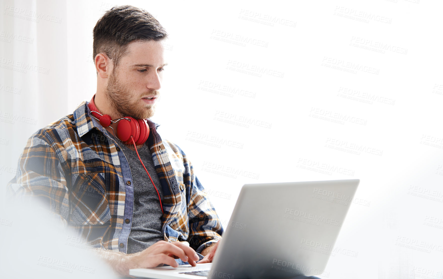 Buy stock photo Man, headphones and typing with laptop for music software, audio or content creation at home. Young, male person or musical artist with headset on computer for digital sound track, app or podcast