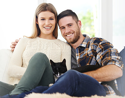 Buy stock photo Portrait of a smiling young couple sitting with their cat on a sofa at home