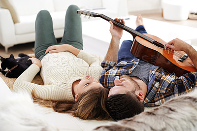 Buy stock photo Young couple, floor and playing guitar for bonding together in relationship with love or support. Woman, man and music instrument for fun, relax and joy in lounge for song, peace and memory in home