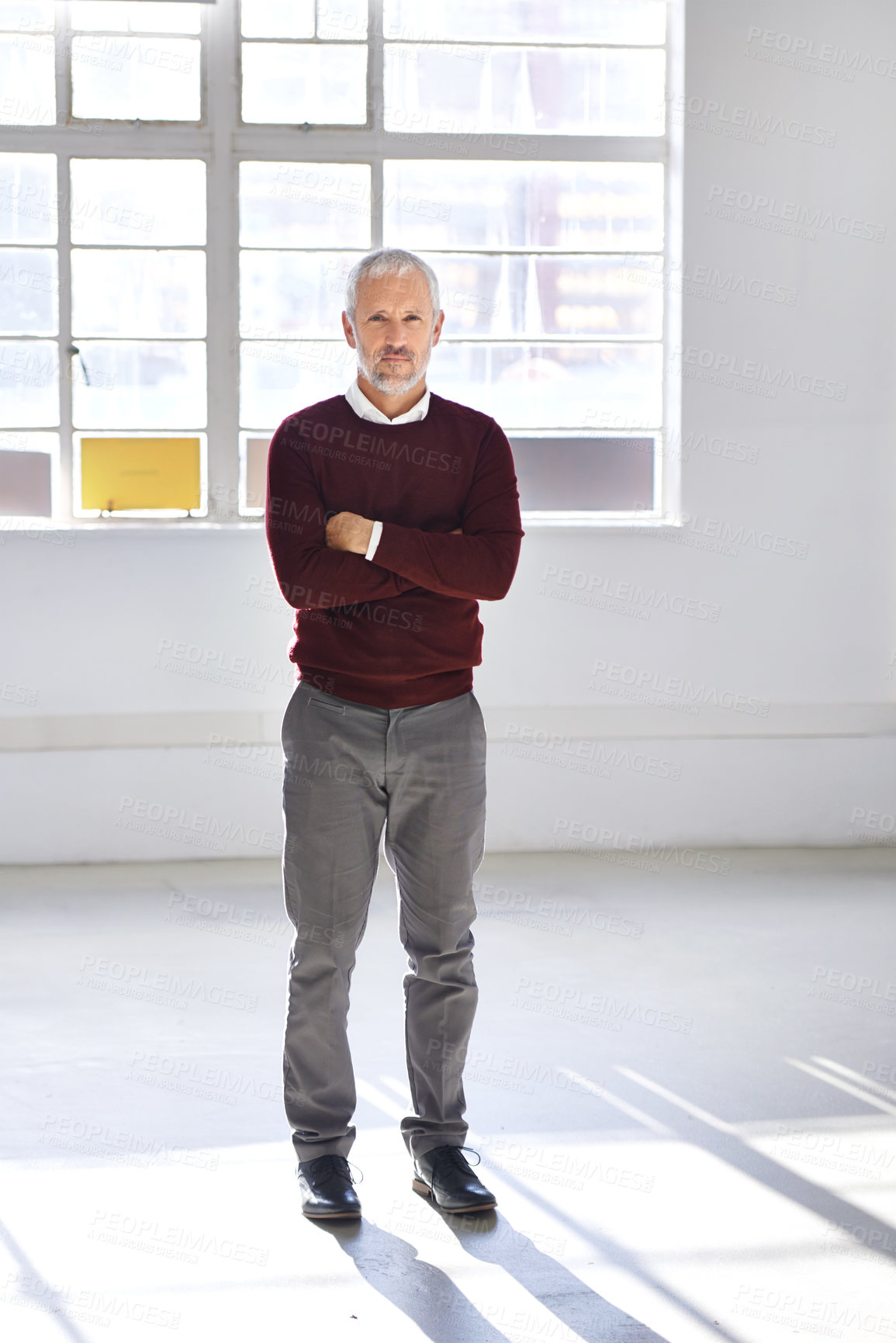 Buy stock photo Portrait of serious mature businessman standing alone with his arms folded in the office. Full length of focused senior professional with assertive attitude. Corporate executive boss feeling powerful