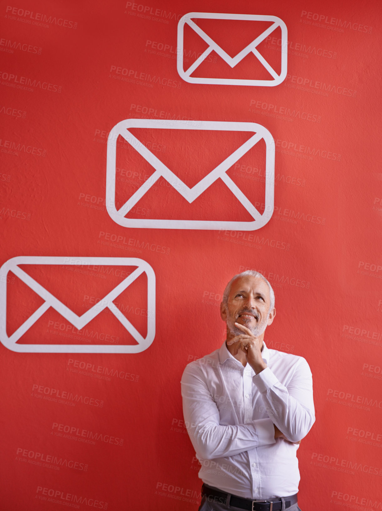 Buy stock photo A mature businessman looking thoughtful while standing against a red background with message symbols