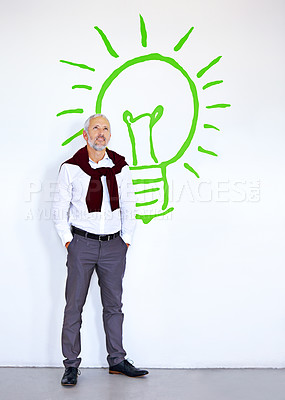 Buy stock photo A mature businessman looking thoughtful while standing in front of a white wall with a lightbulb on it