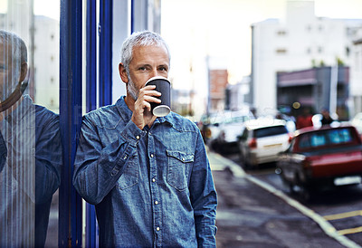 Buy stock photo Portrait of a handsome mature man drinking takeaway coffee while out in the city