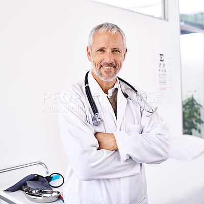 Buy stock photo Portrait of a handsome mature doctor standing in a hospital room