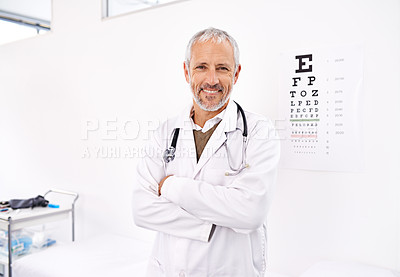 Buy stock photo Portrait of a mature male optometrist standing in his office with an eye chart in the background