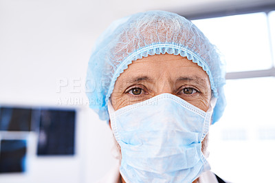 Buy stock photo Shot of a mature male surgeoun wearing a surgical mask and cap