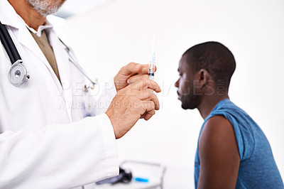 Buy stock photo Cropped shot of a male doctor preparing a syringe before giving his patient an injection 