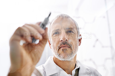 Buy stock photo Shot of a mature male scientist drawing the structures of molecules on a glass surface
