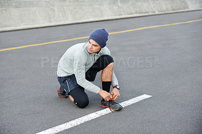 Buy stock photo Athlete, man or tie shoelace in city for morning jog, fitness or getting ready for cardio workout in street. Runner, person and prepare running shoes in urban road for exercise, training and marathon