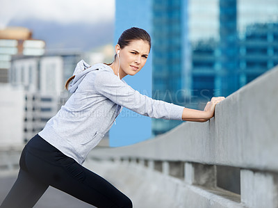 Buy stock photo Portrait of a young female jogger stretching on the street before a run
