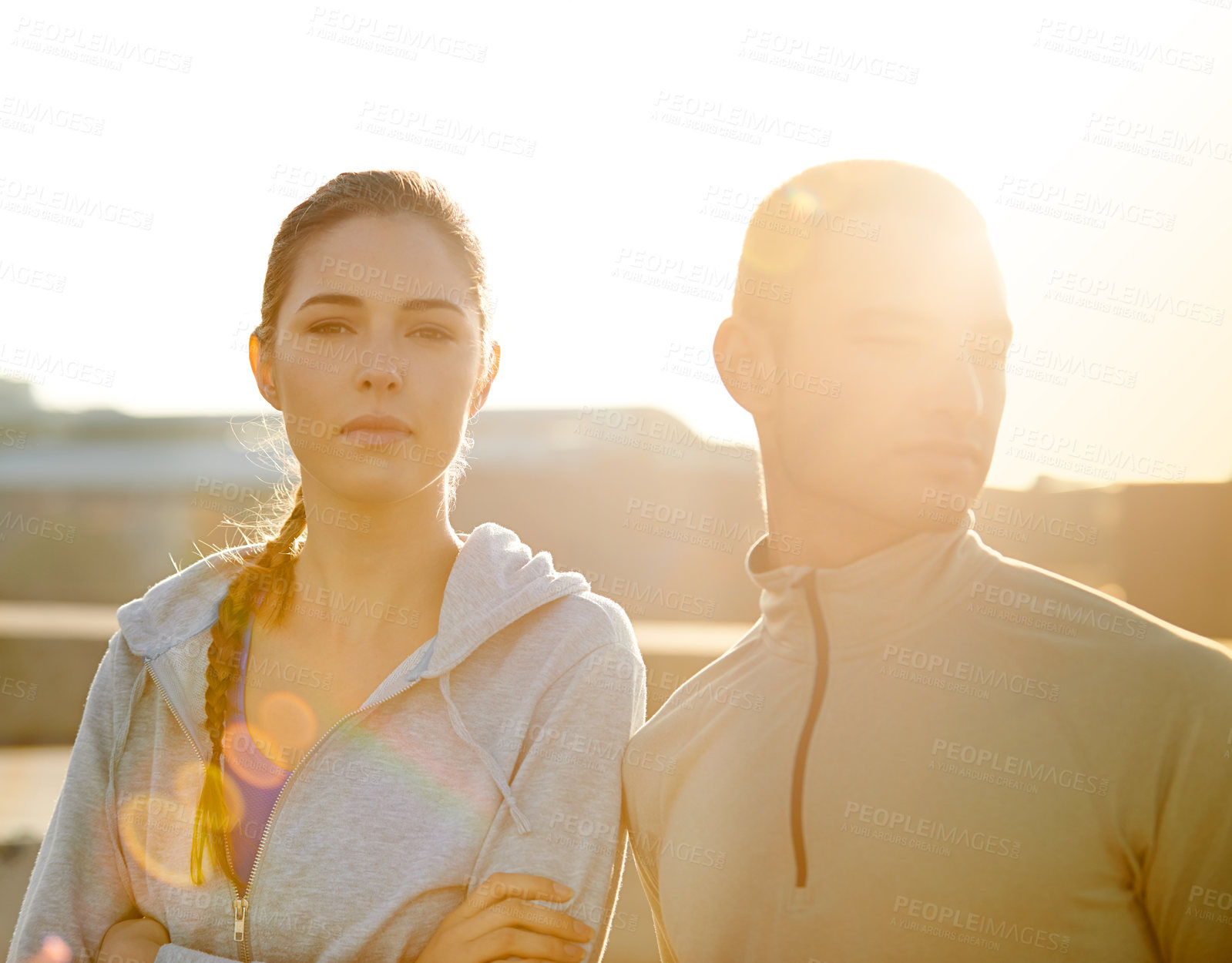 Buy stock photo Runner, woman and man in city at sunrise, portrait and arms crossed for fitness, training and health in morning. People, pride and workout on metro road for exercise, teamwork and ready for marathon
