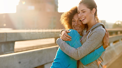 Buy stock photo Portrait of two female joggers hugging each other and laughing before a run through the city